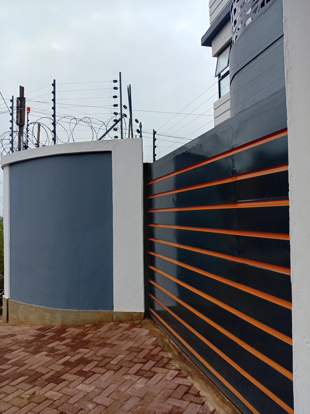 Modern compound gate with orange and black horizontal slats