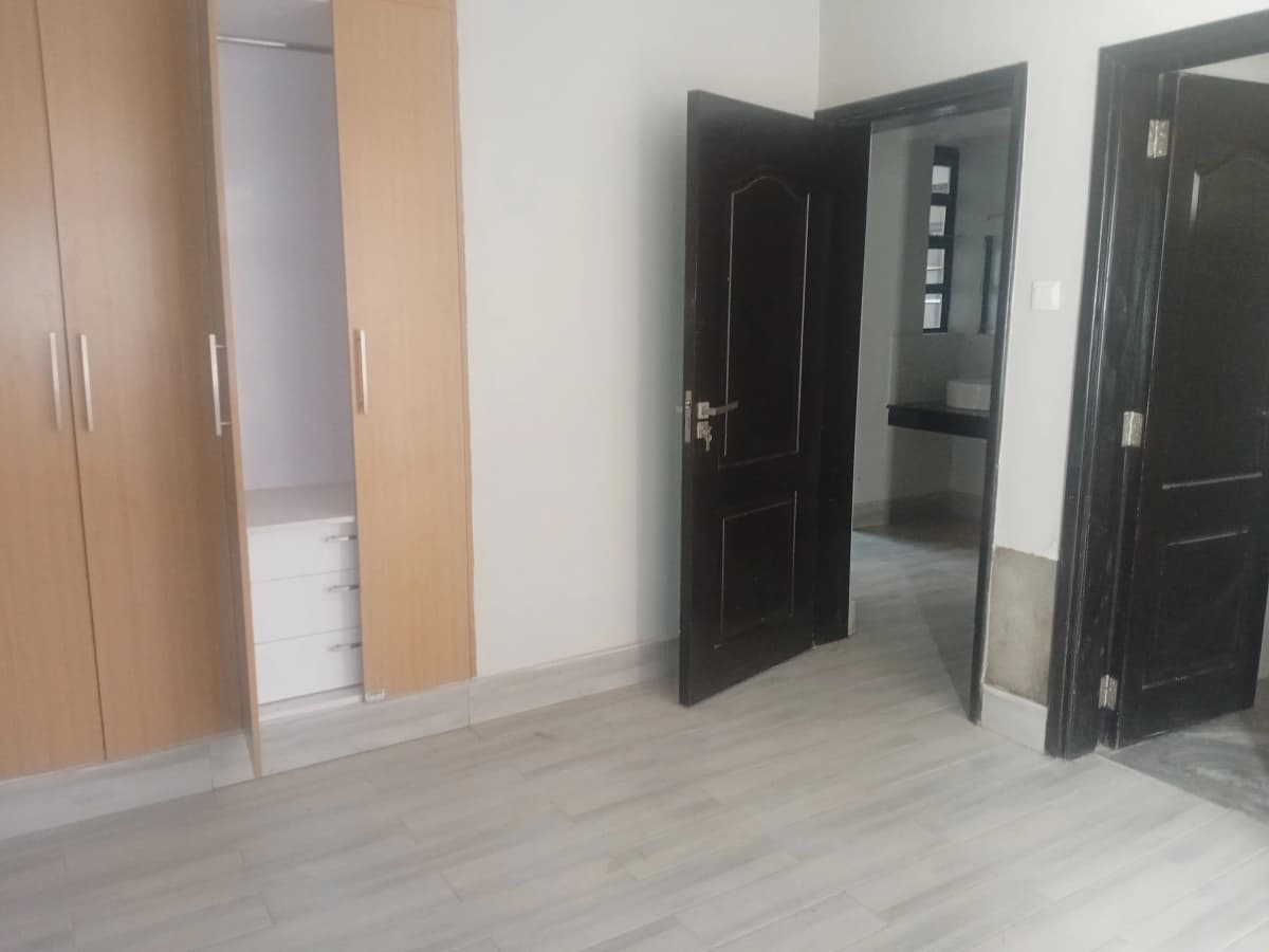 Spacious bedroom with wooden wardrobes and black doors
