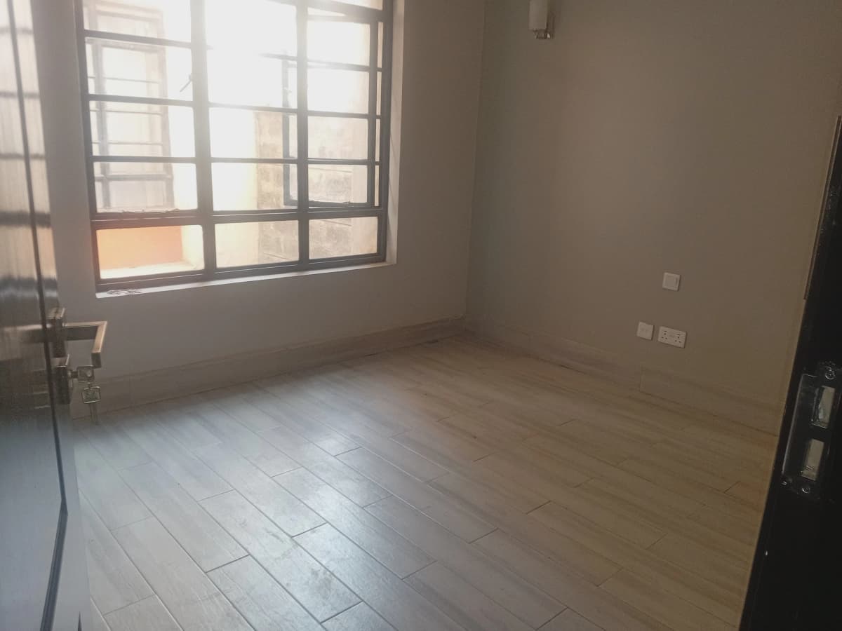 Empty living room with wooden flooring and large window