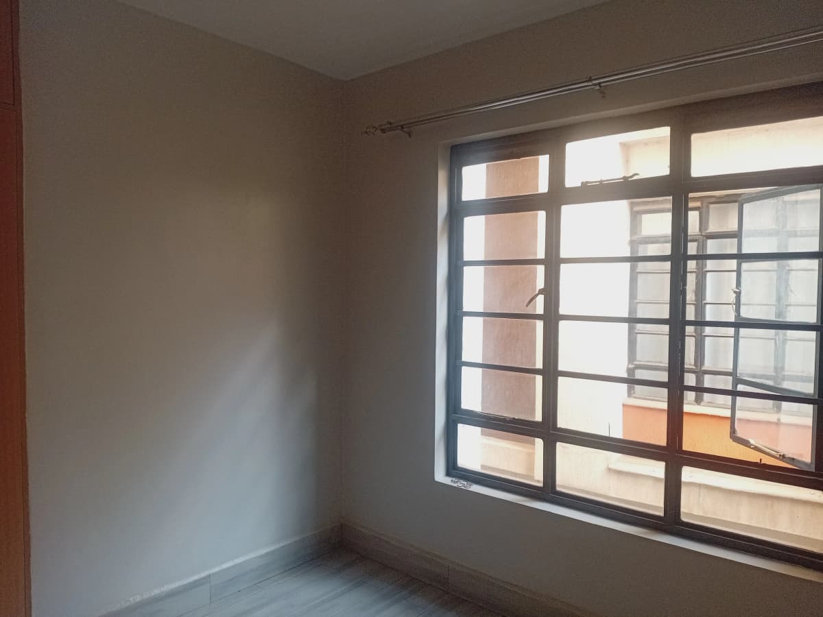 Unfurnished bedroom with large window and natural light