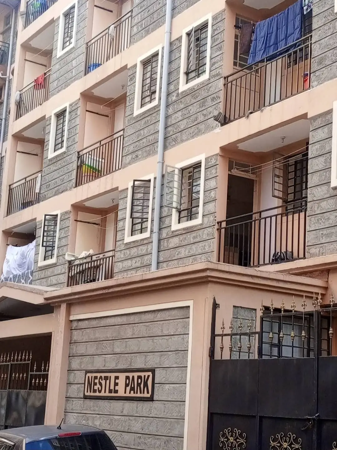 Multi-story residential building facade with balconies and gate