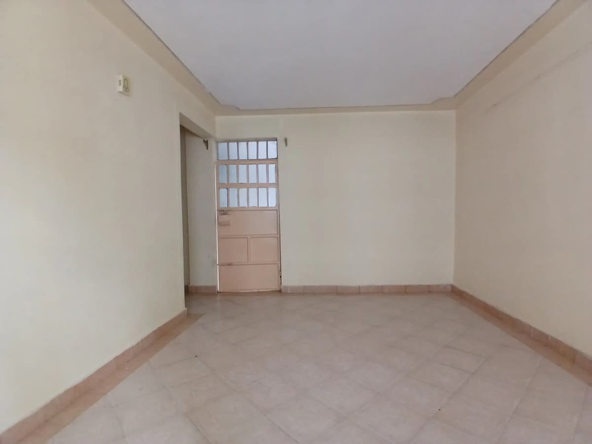 Empty living room with tiled flooring and natural light