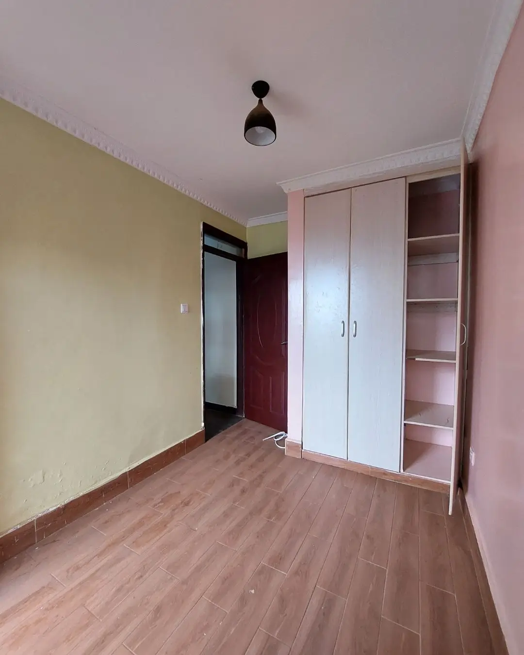 Spacious bedroom with built-in wardrobes and wooden flooring