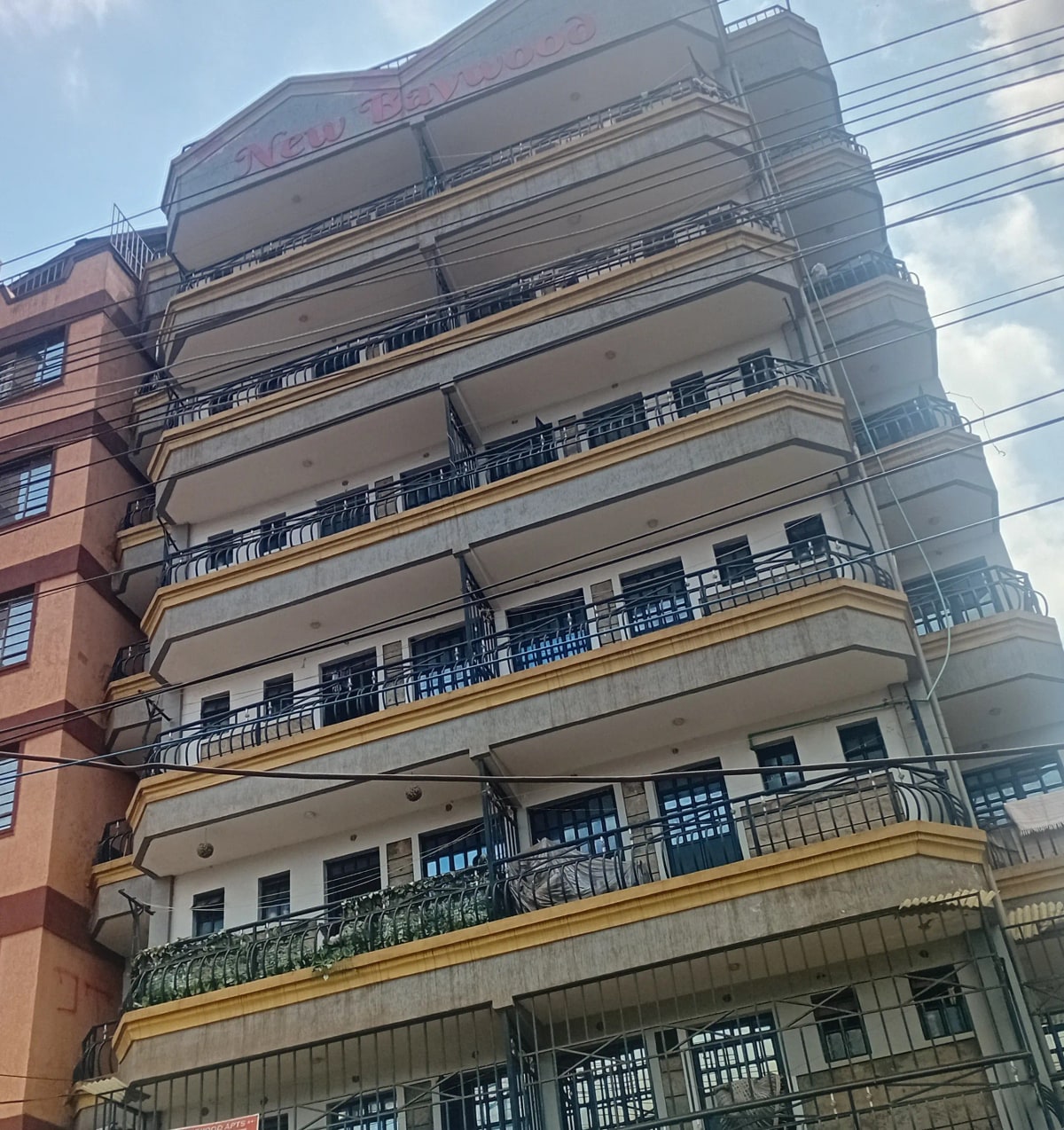 Multi-story residential building facade with balconies and yellow trim