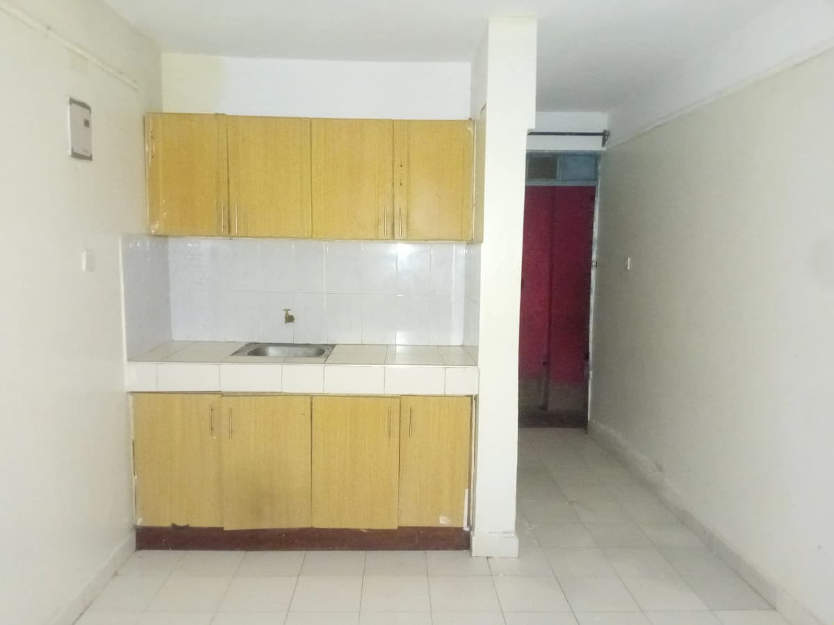 Compact kitchen with yellow cabinets and white tile backsplash