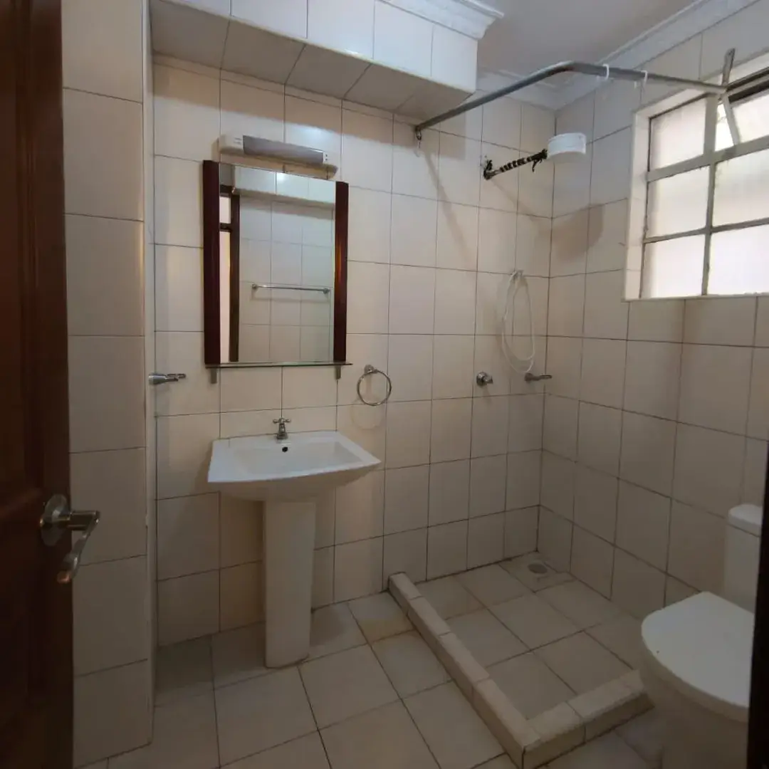 Spacious bathroom with pedestal sink, shower enclosure, toilet