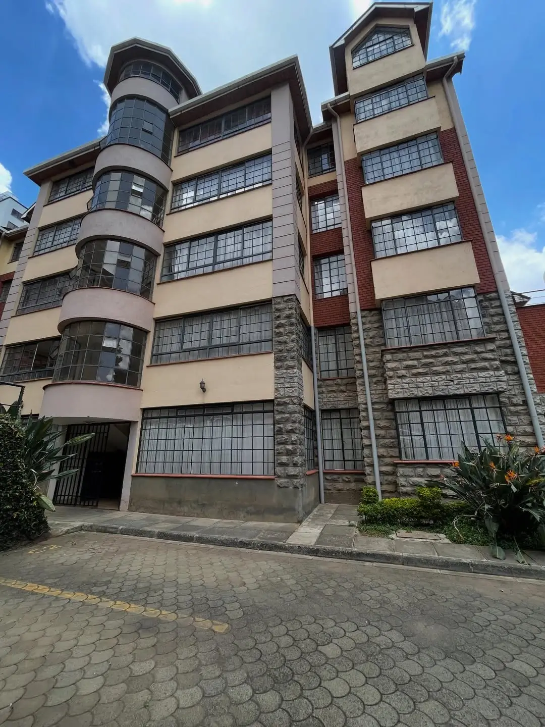 Multi-story residential building facade with cylindrical tower feature