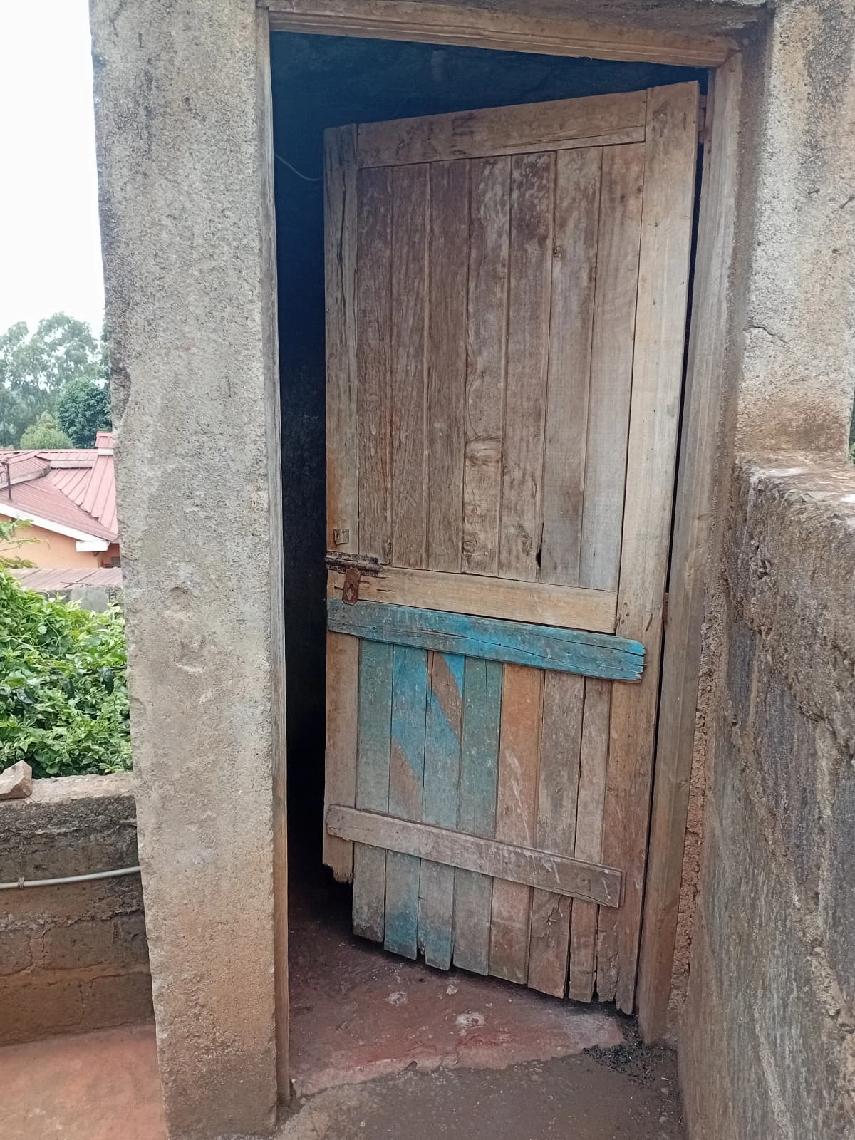 Weathered wooden door entrance with concrete surround