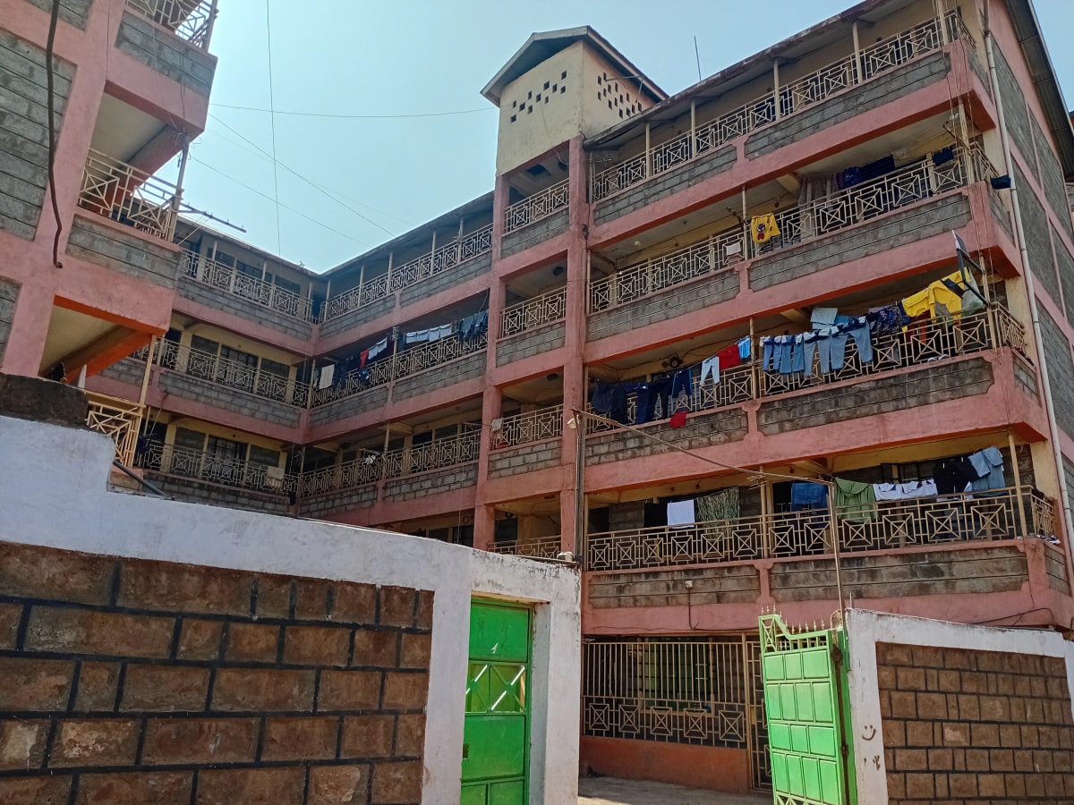 Multi-story residential building with red facade and balconies
