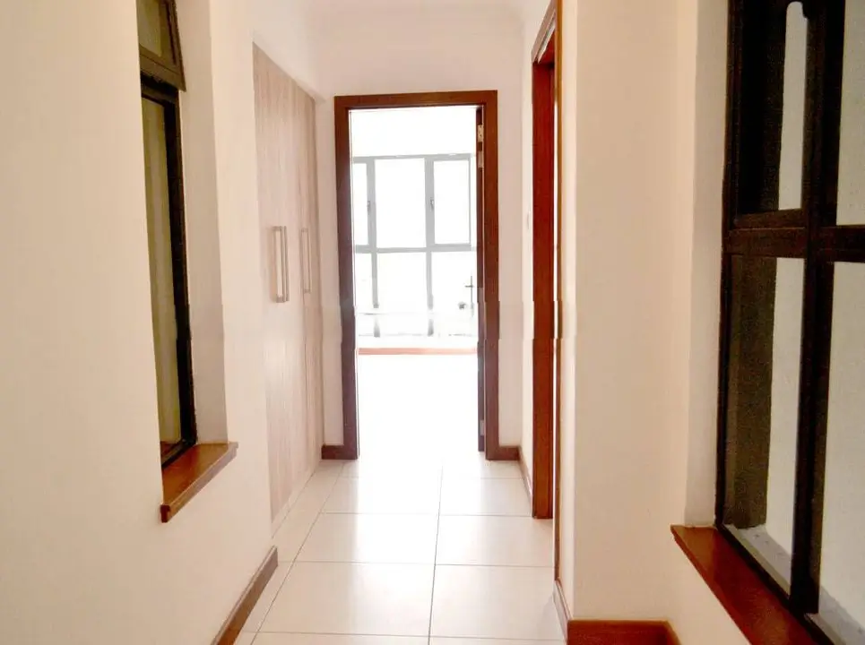 Bright hallway with tiled floor and wooden door frames