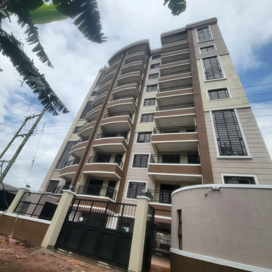 Modern multi-story residential building with balconies and gate