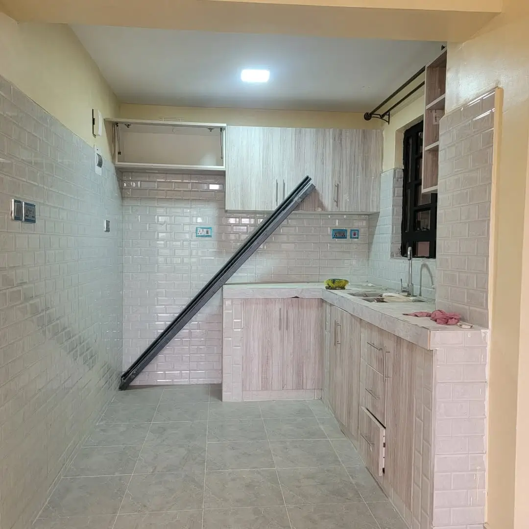 Modern kitchen with pink cabinetry and white tile backsplash