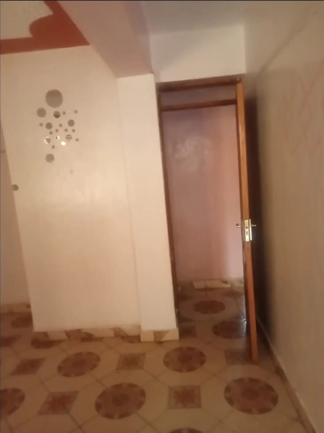 Bare bedroom with patterned floor and wooden door frame