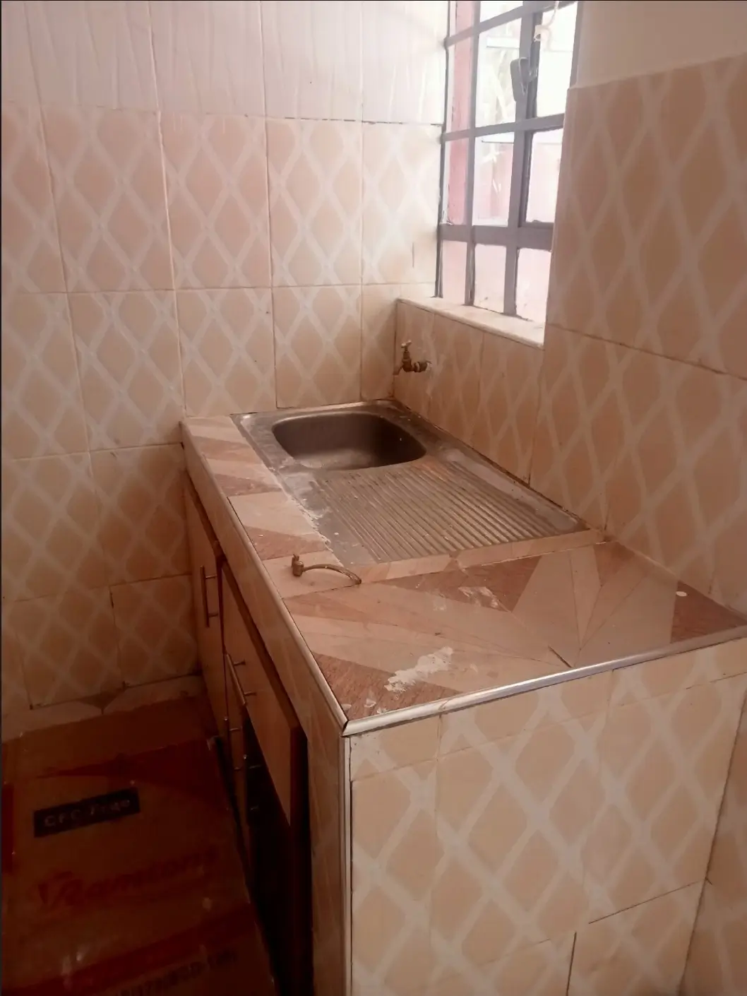 Basic laundry room with tiled sink and washboard setup