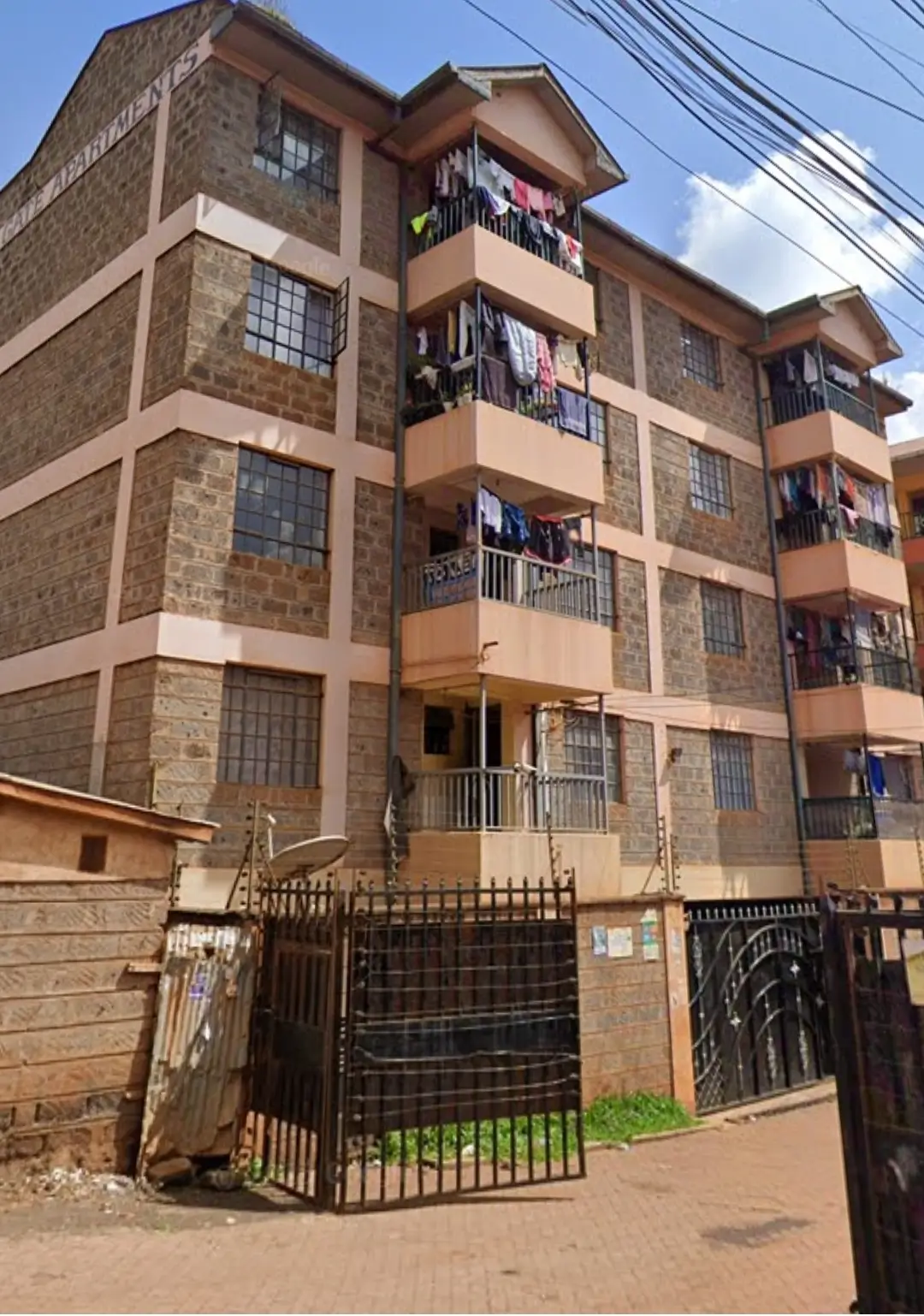 Multi-story residential building with stone facade and metal gates