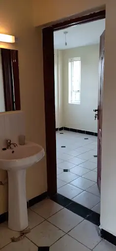 Compact bathroom with pedestal sink and tiled flooring
