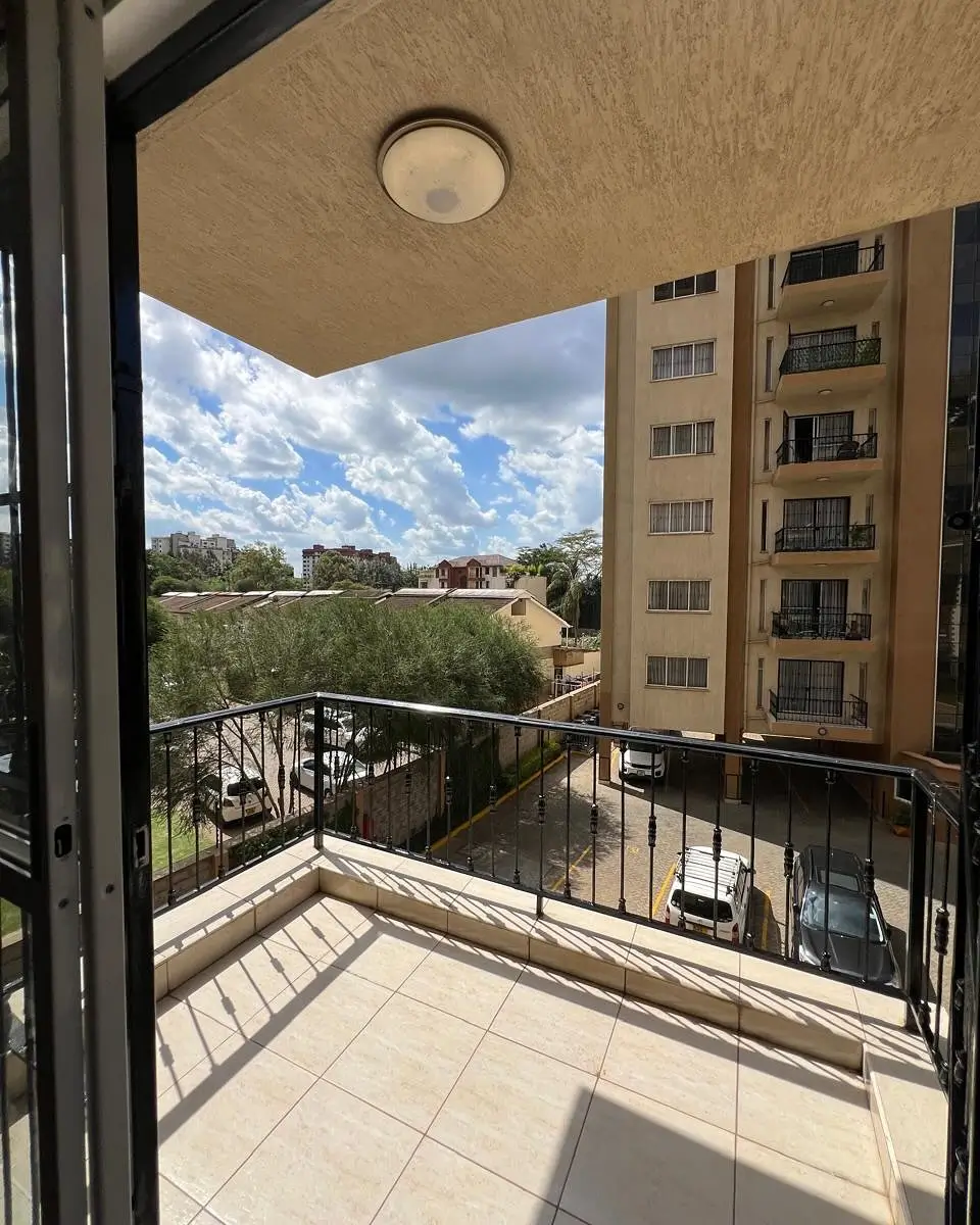 Balcony overlooking green landscape with apartment building
