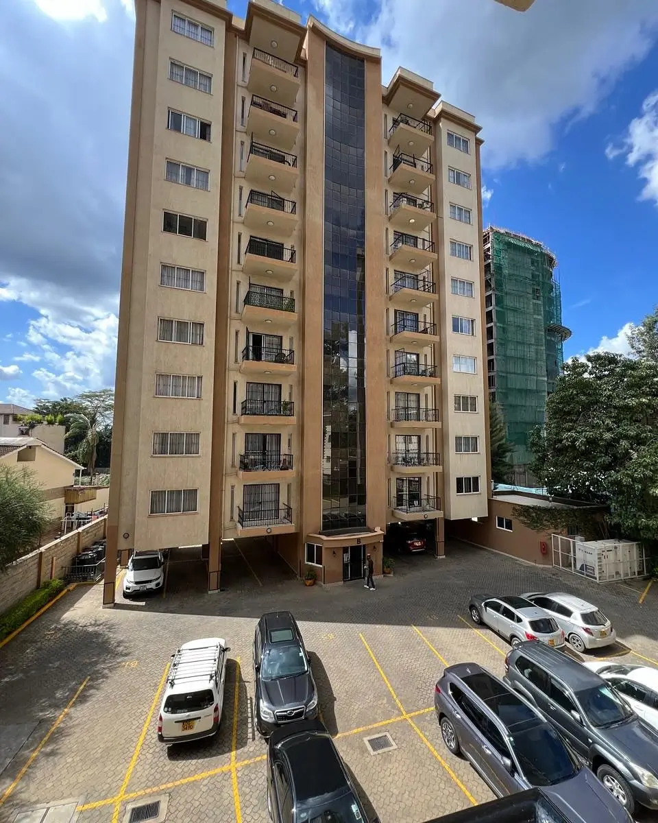 Multi-story residential building with ground-level parking lot