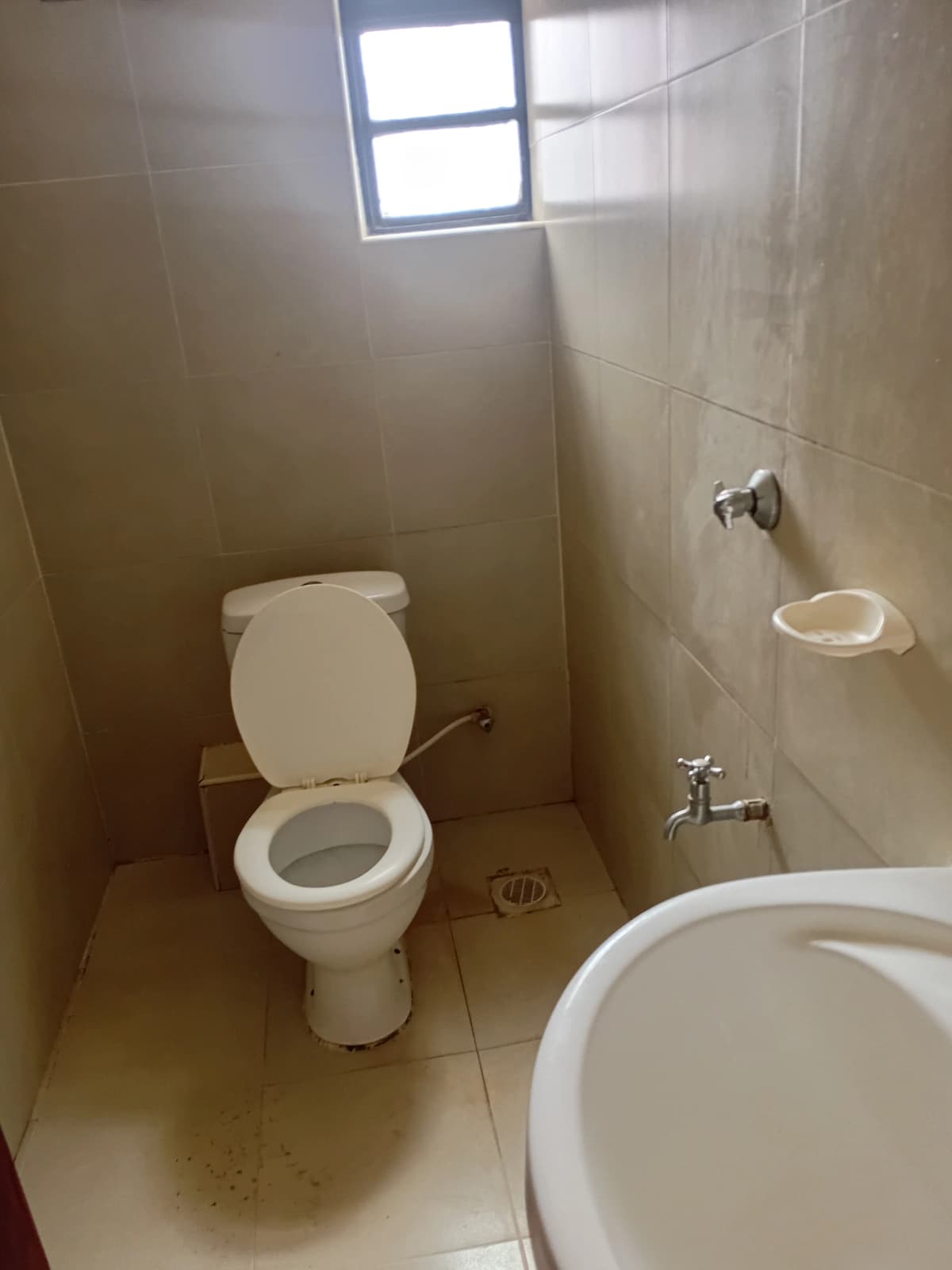 Compact bathroom with toilet, sink, and shower cubicle