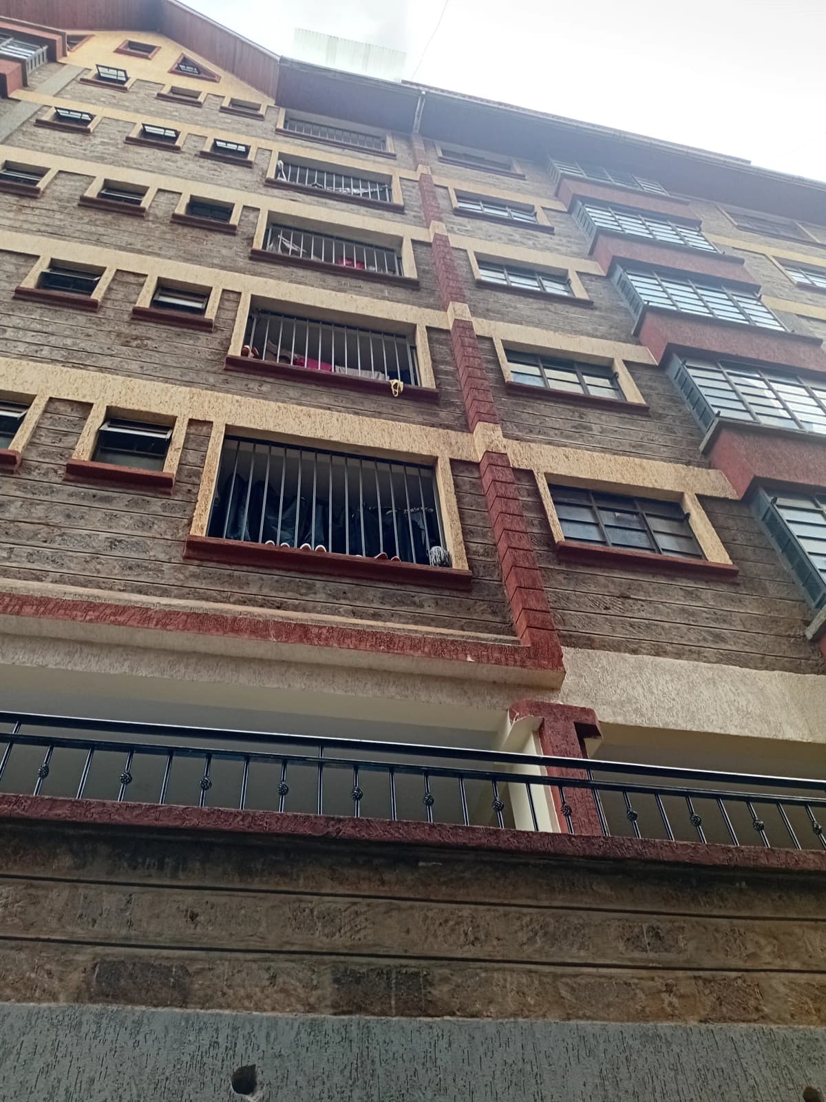 Multi-story brick apartment building facade with barred windows