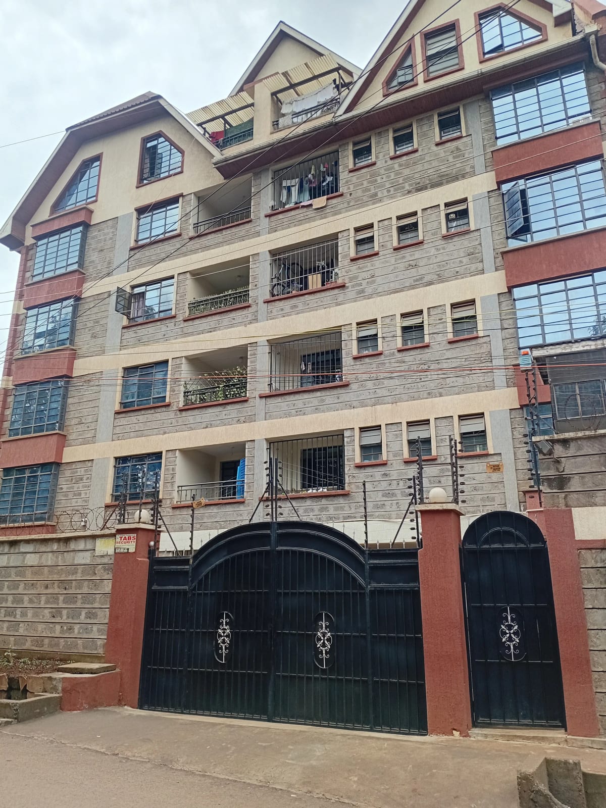 Multi-story residential building with gated entrance and balconies