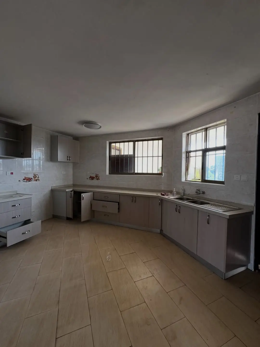 Spacious kitchen with brown cabinetry and tile flooring