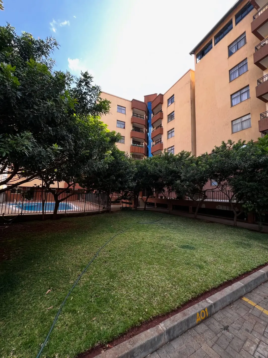 Manicured compound lawn with multi-story residential building backdrop