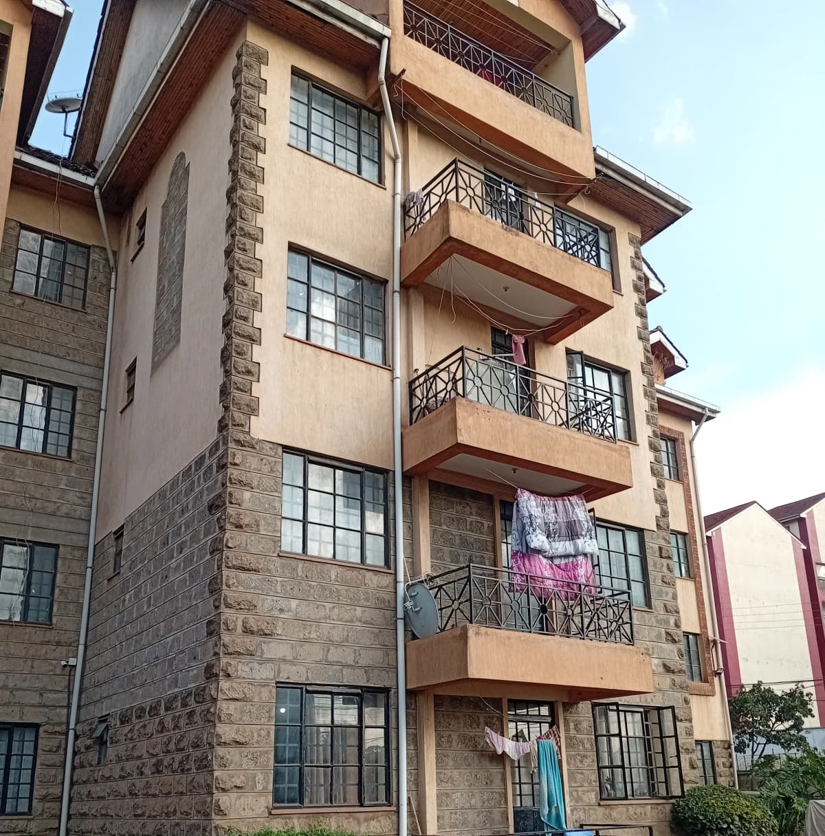 Multi-story residential building facade with balconies and stone accents