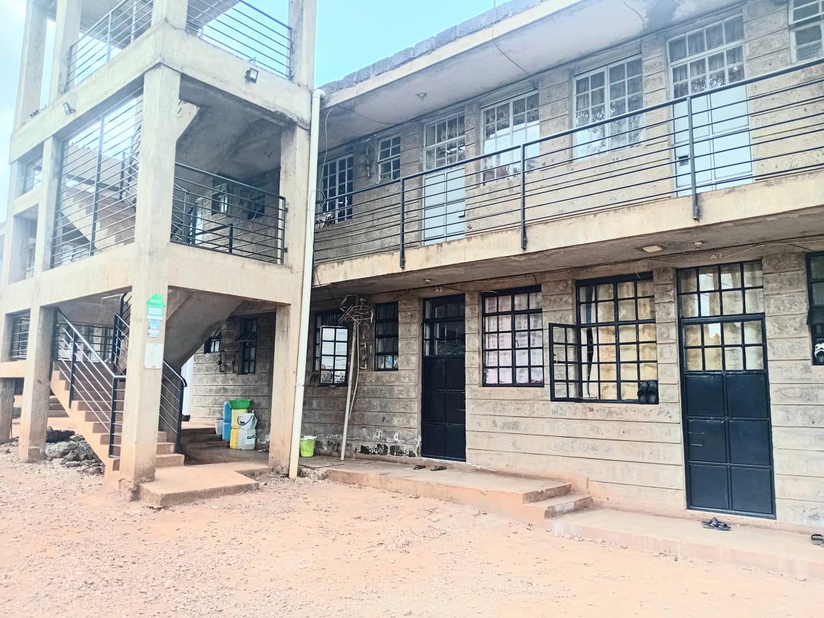 Multi-story residential building facade with ground-level entrance and stairs