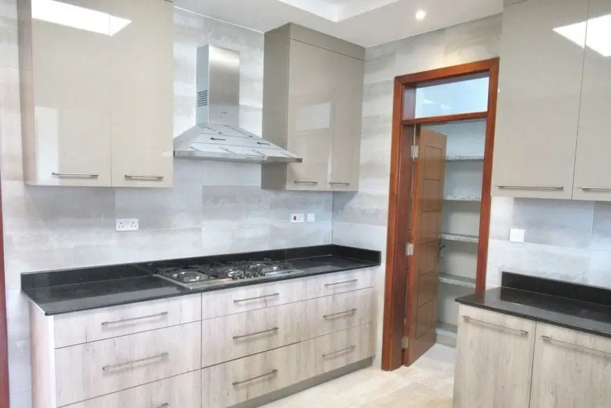 Modern kitchen with white cabinetry, black countertops, gas cooktop