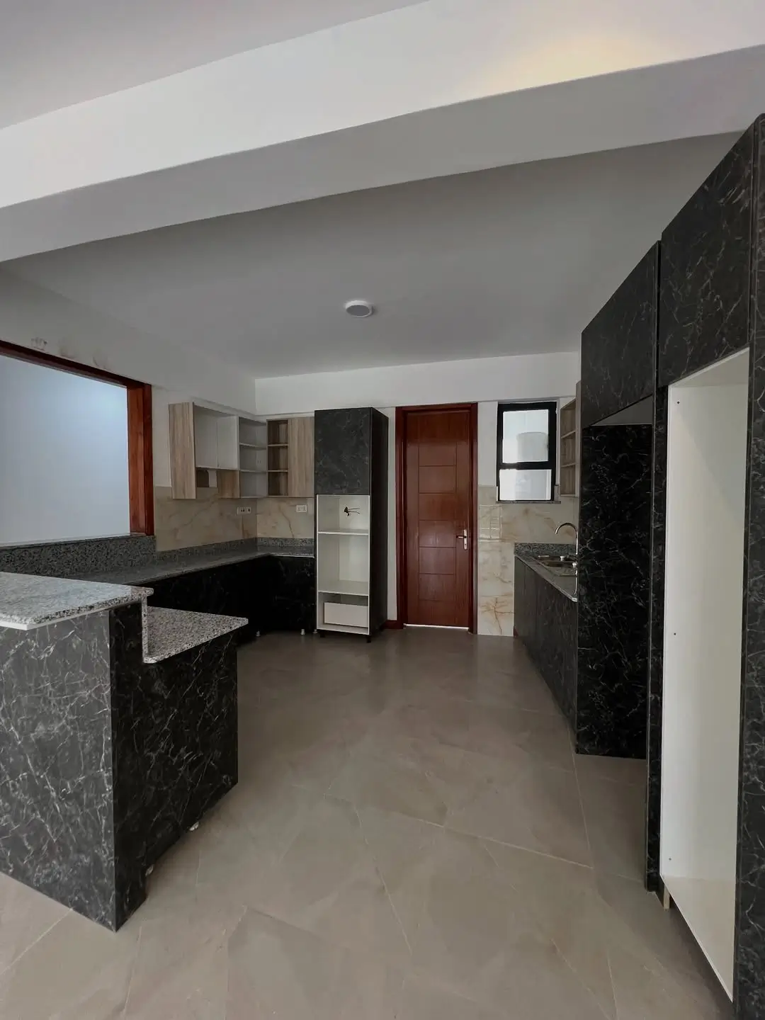 Modern open-plan kitchen with black marble counters and island