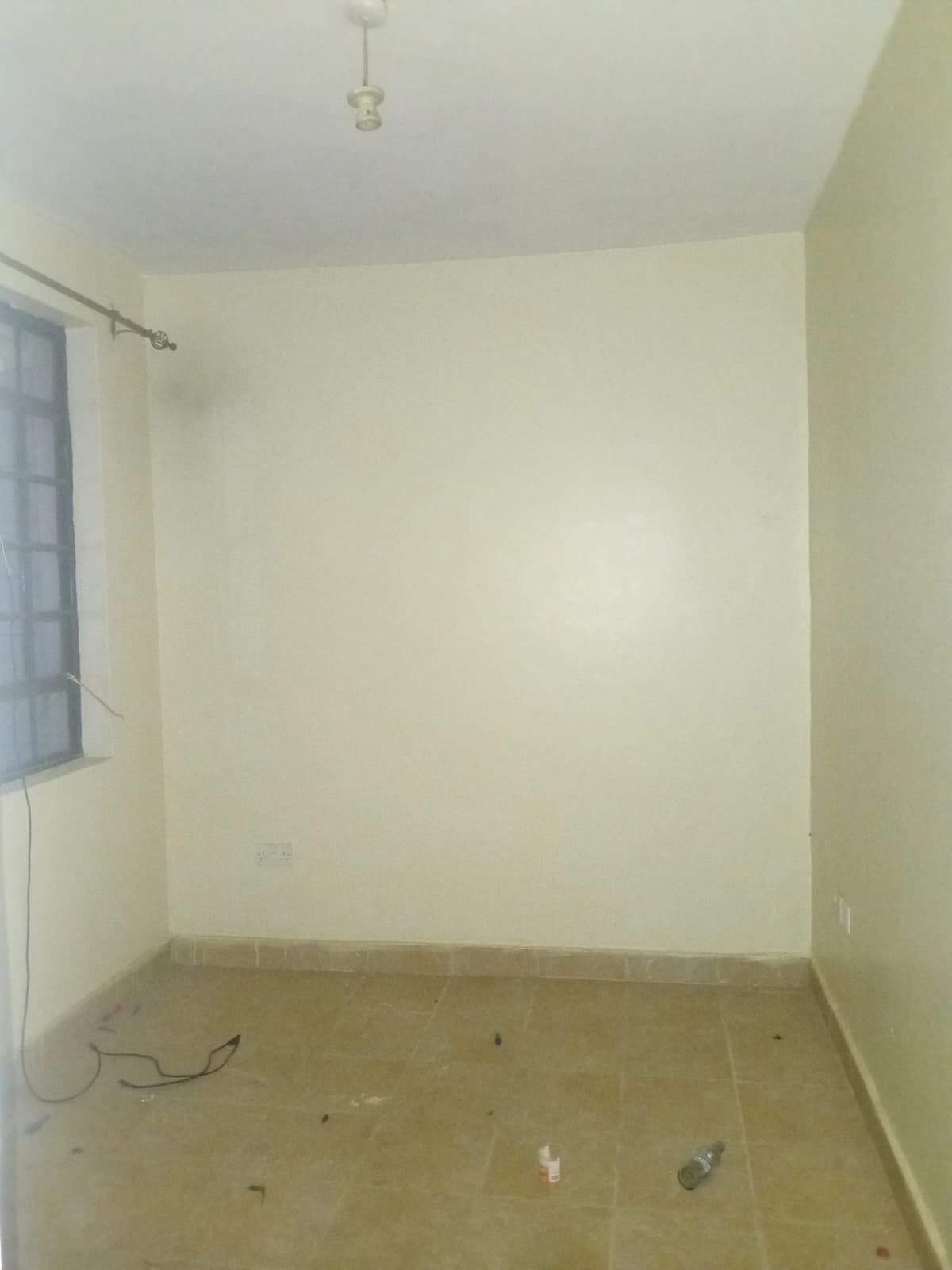 Empty bedroom with cream walls and concrete floor.