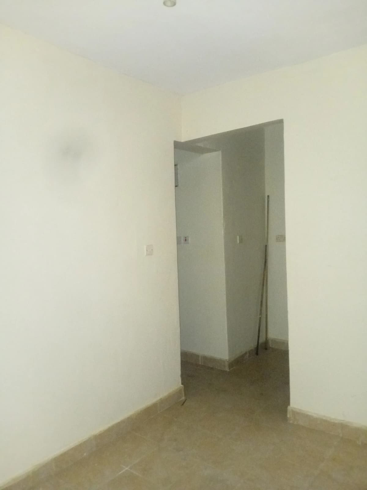Empty bedroom with doorway, bare concrete floor