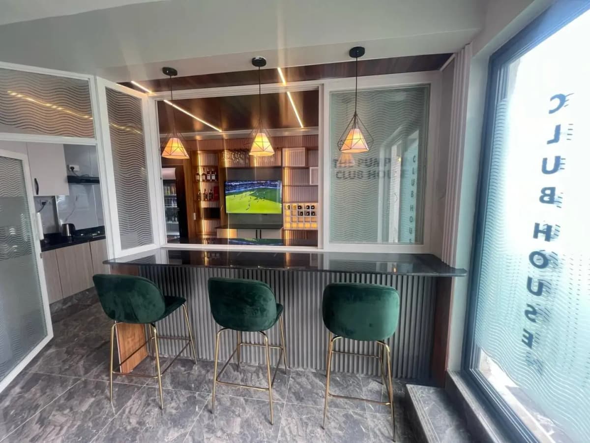 Modern kitchen with bar counter, pendant lights, and integrated TV