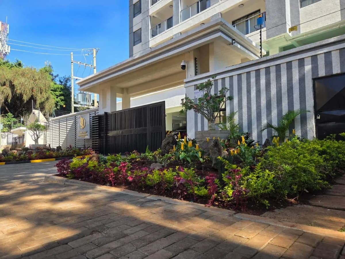 Modern building entrance with landscaped flower beds and gate