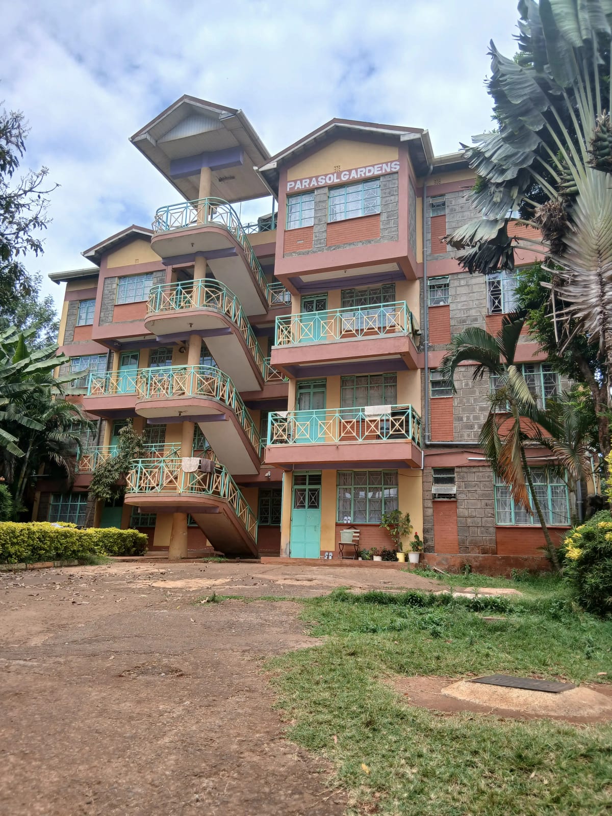 Multi-story brick residential building with manicured compound grounds