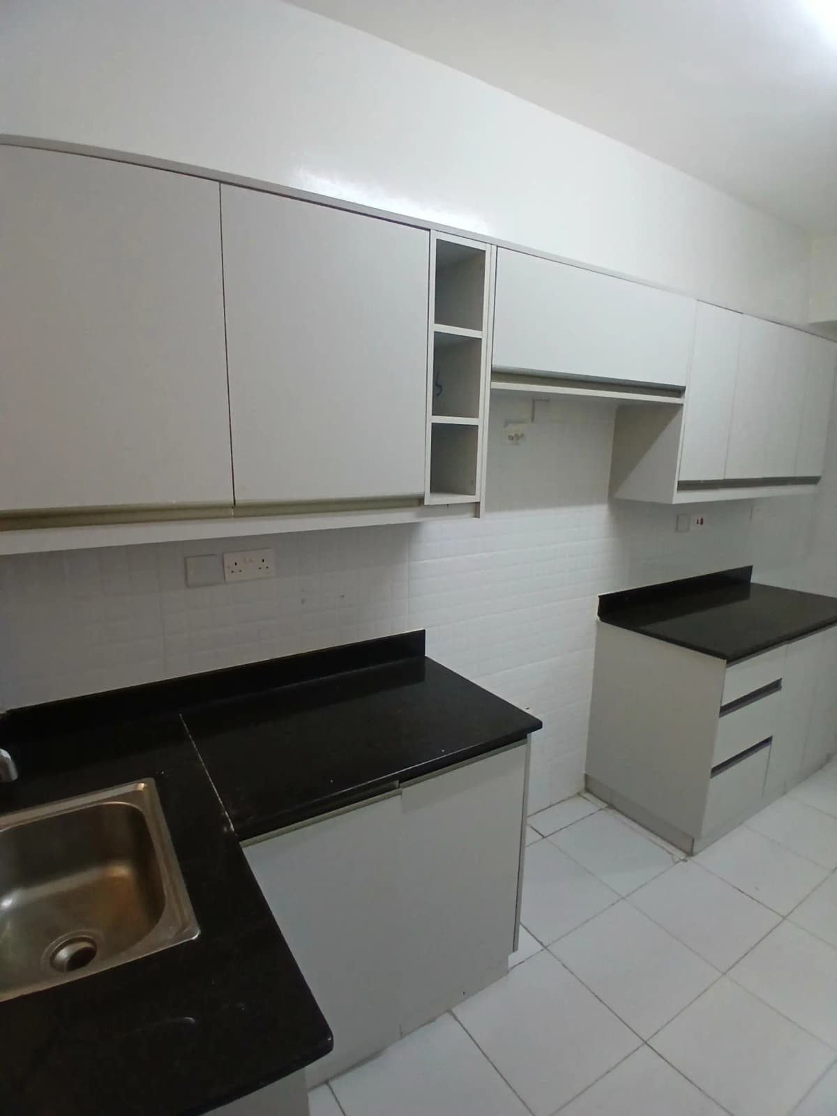 Dedicated pantry with white cabinetry and black countertops