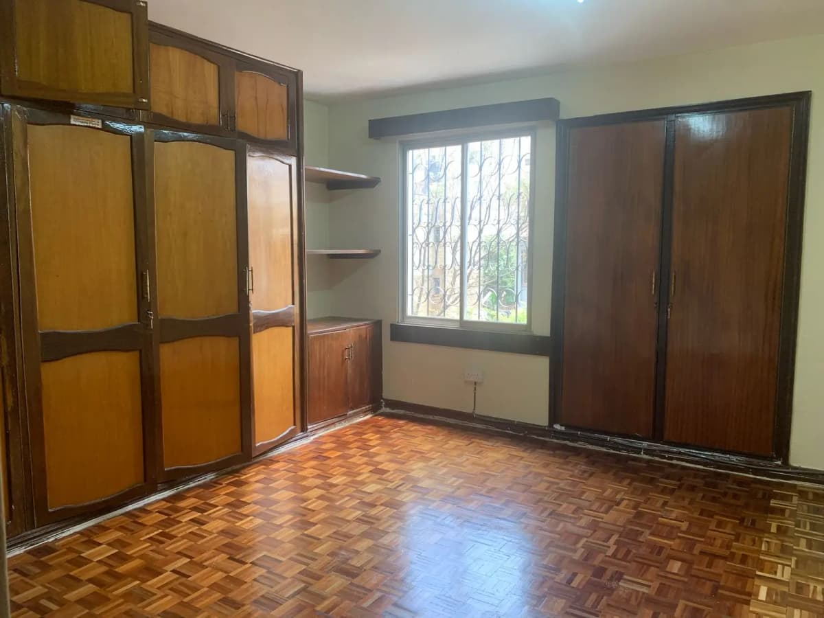 Spacious bedroom with wooden wardrobe and parquet flooring