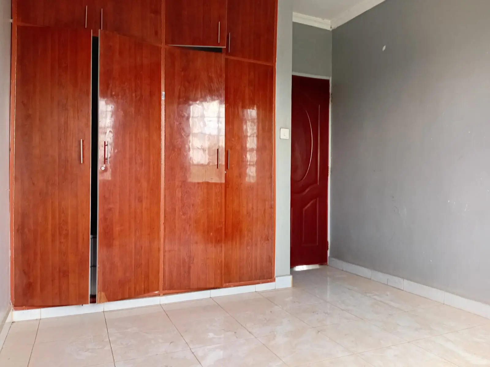 Bedroom with red wood built-in wardrobe and tiled floor