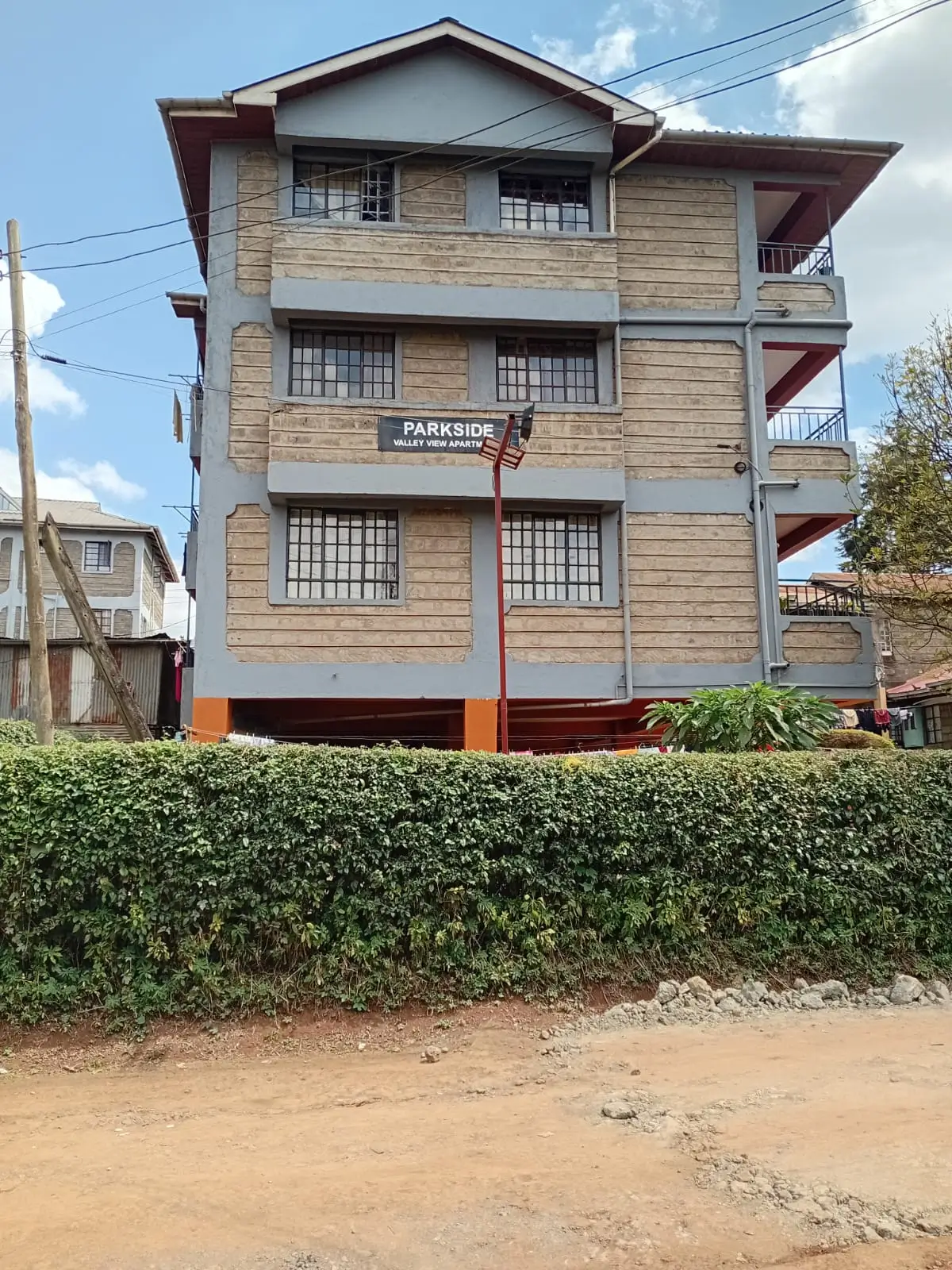 Three-story residential building with cream facade and balconies