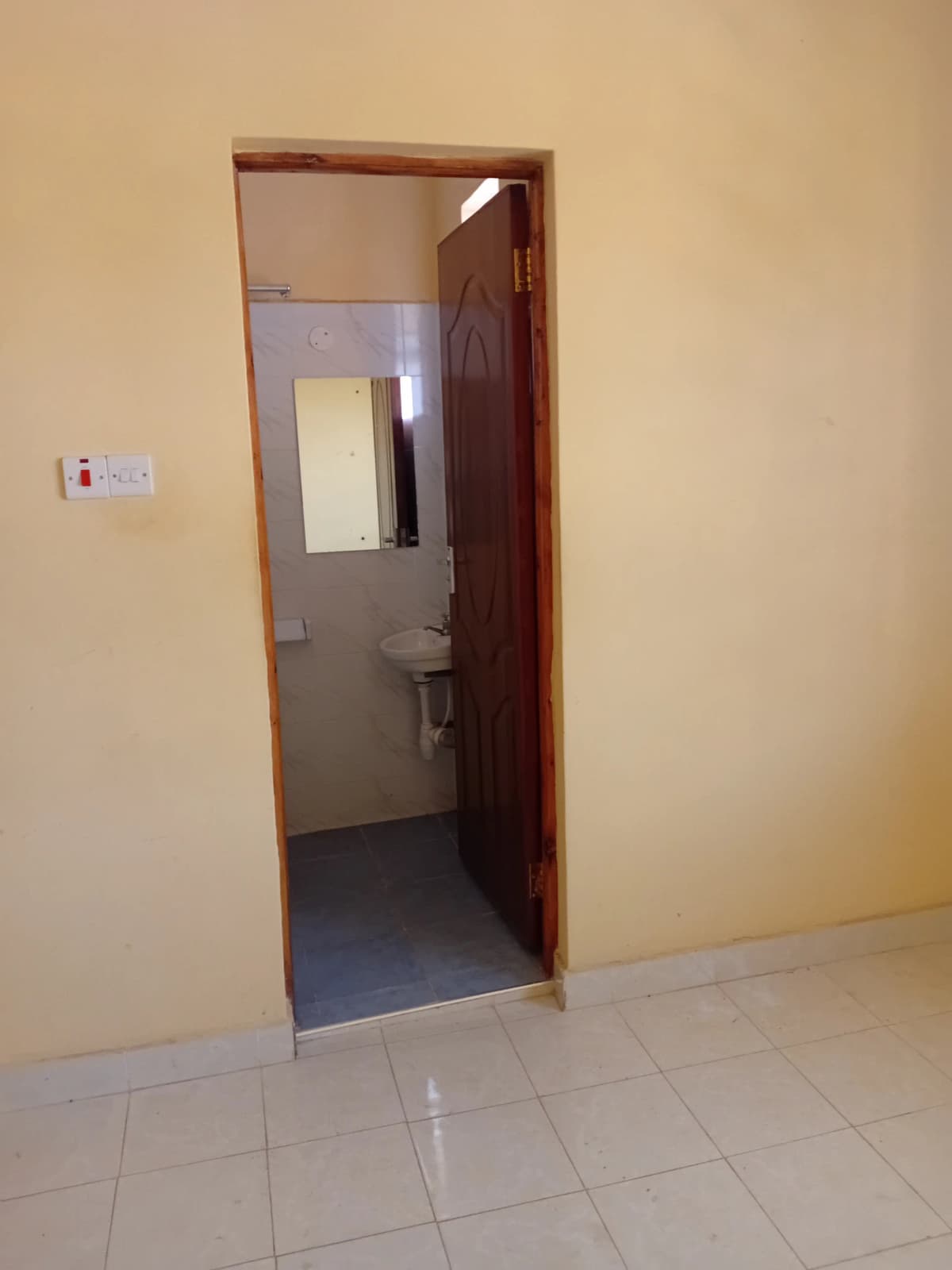 Compact bathroom with toilet and sink visible through doorway