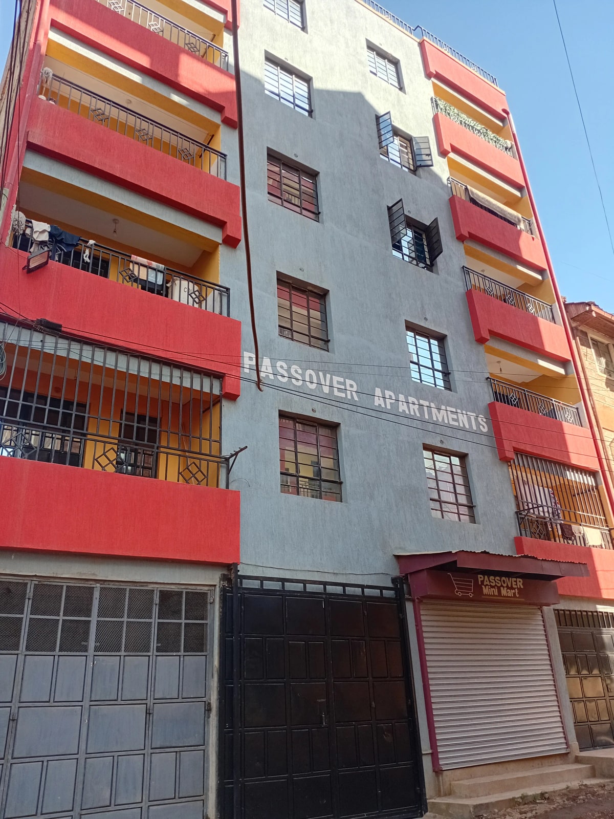 Multi-story residential building facade with red and gray painted exterior