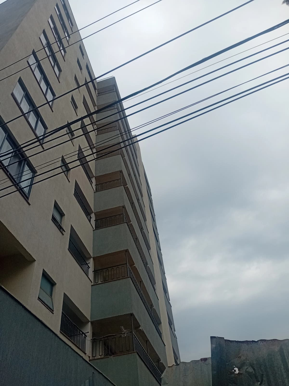 Multi-story residential building facade with balconies and power lines