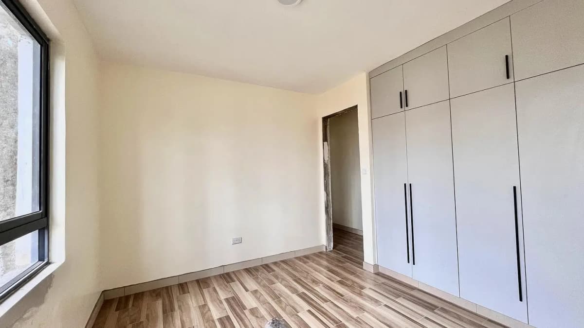 Spacious bedroom with built-in wardrobes and wooden flooring