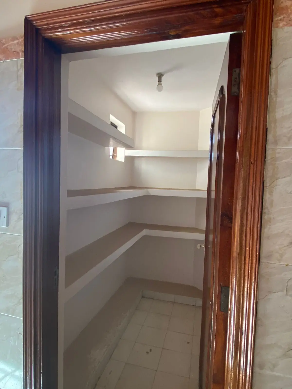 Empty pantry with wooden frame and built-in shelving