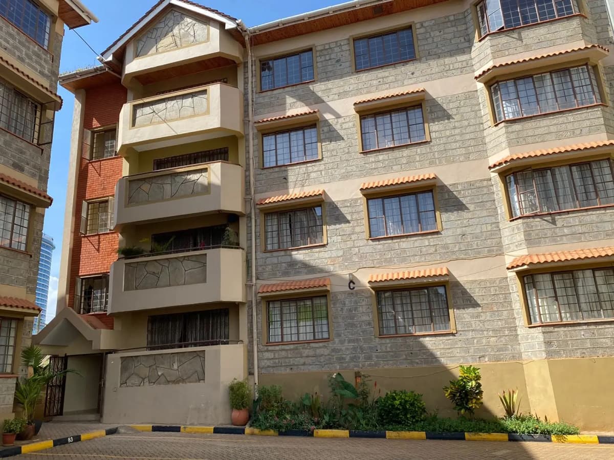 Multi-story residential building facade with stone and render finish