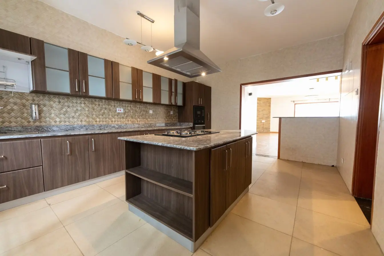 Modern kitchen with island, dark cabinetry, and open-plan dining area