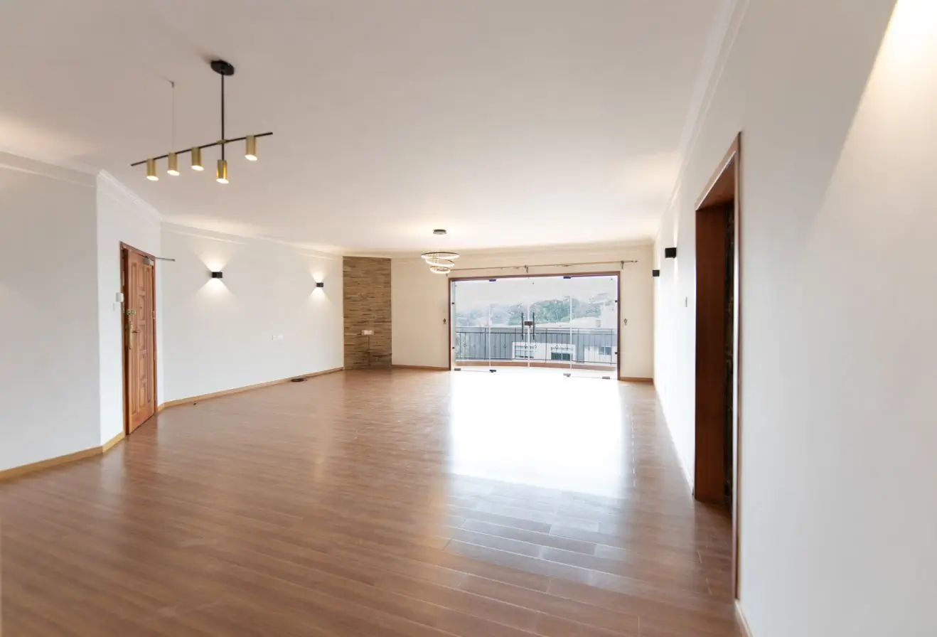 Spacious open-plan living area with wooden floors and natural light