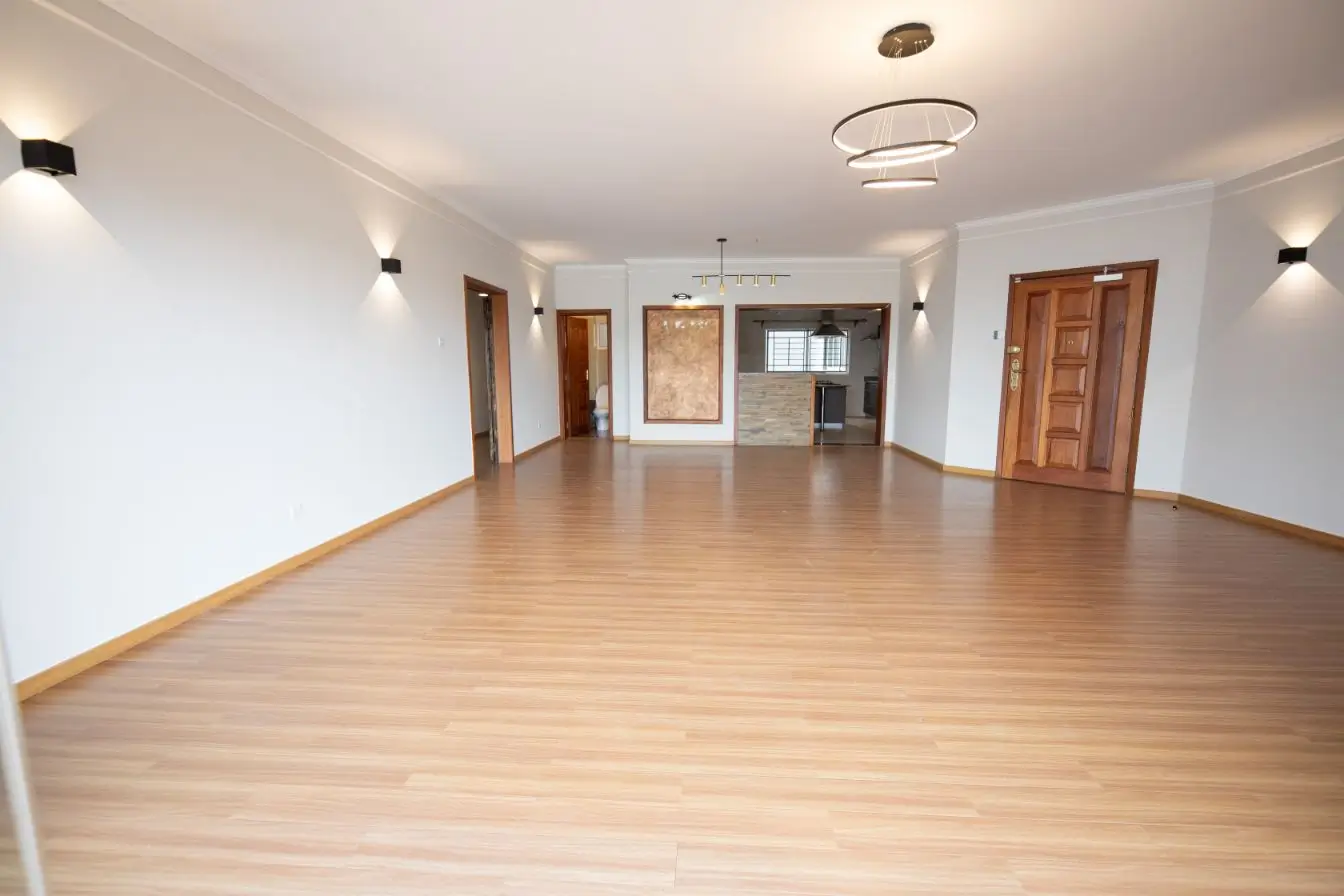 Spacious open-plan living area with wooden flooring throughout