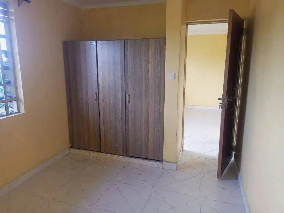 Bedroom with wooden wardrobe and cream-painted walls